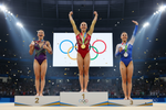 Three female gymnasts standing on award podium at the olympics