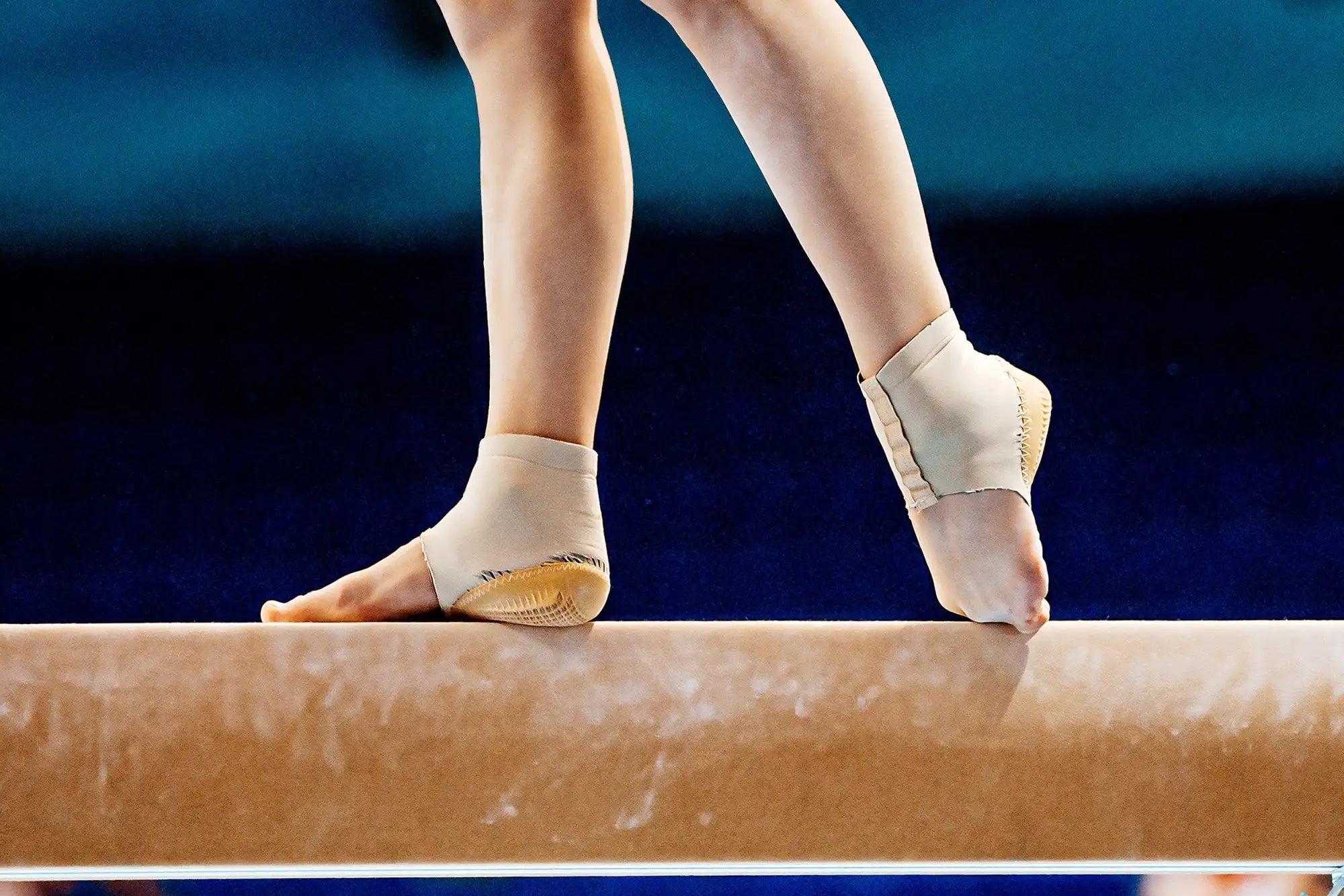 Woman performing on gymnastics balance beam.