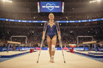 A blue sequined gymnastics leotard with mesh sleeves and a deep v-neckline