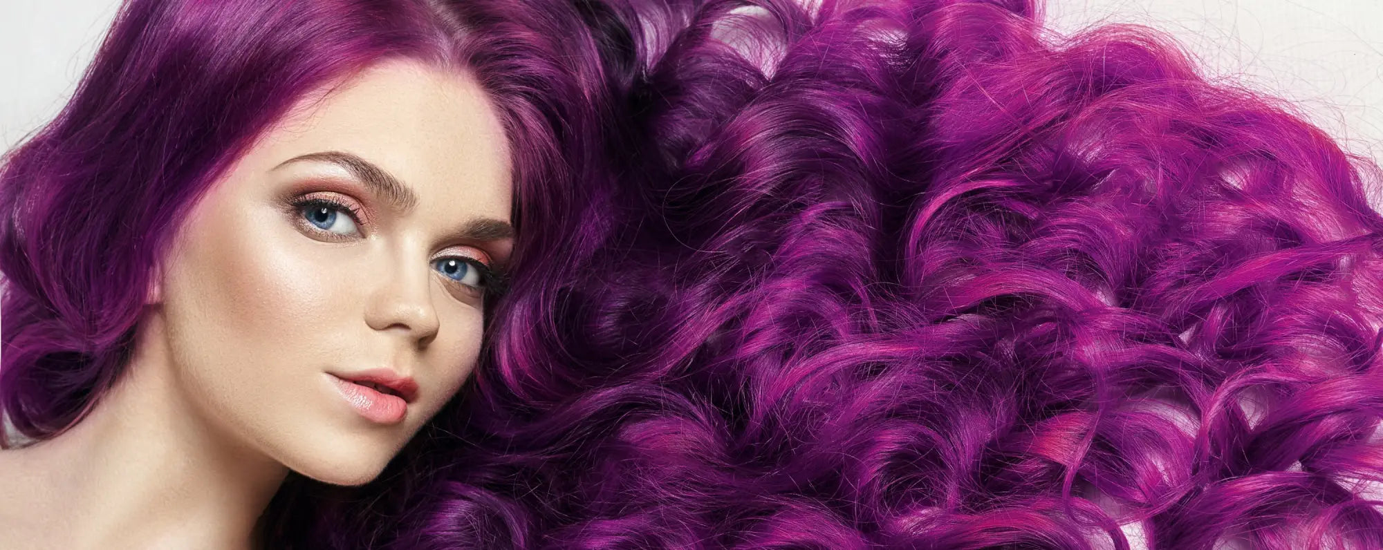 Vibrant purple curly gymnastics hairstyle ponytail over shoulder