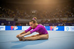 A vibrant purple gymnastics leotard with sparkling embellishments perfect for dynamic stretching during floor routines in pan american gymnastics