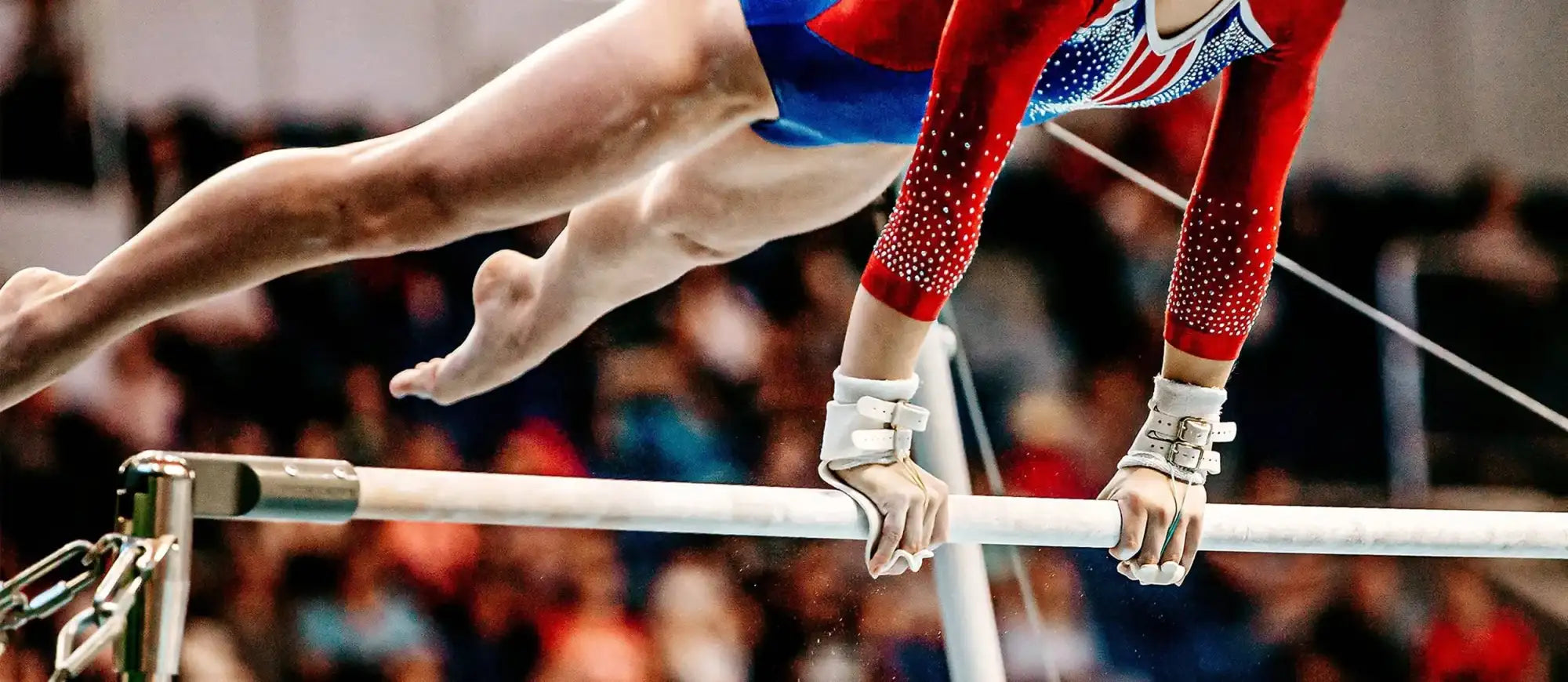 Gymnast in sparkling leotard on bars at NCAA gymnastics semifinals